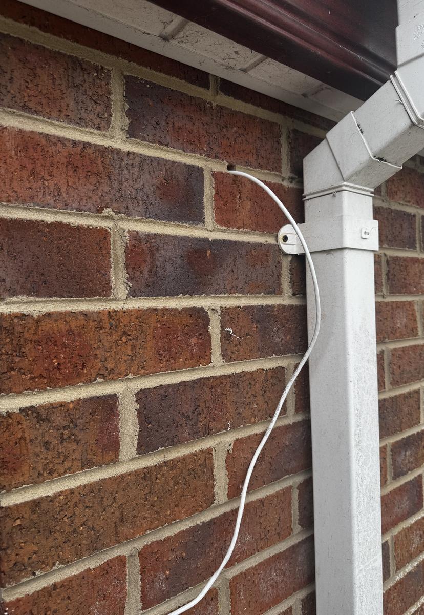 Camera cable run tight to the downpipe and clipped neatly
