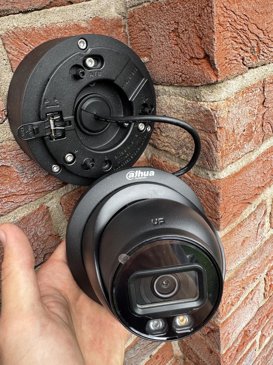 Black dome camera being fitted to its base