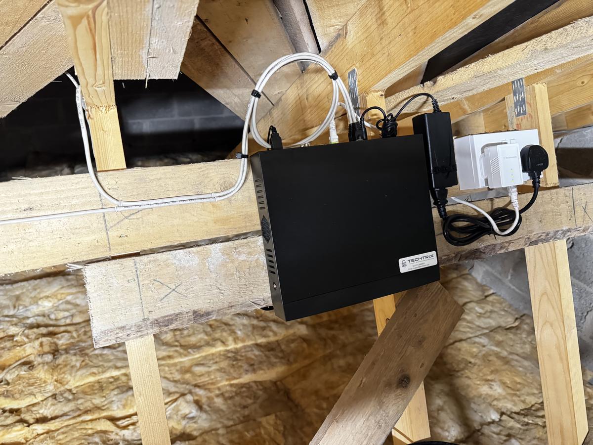 Loft-mounted CCTV recorder with cables dressed along the timbers
